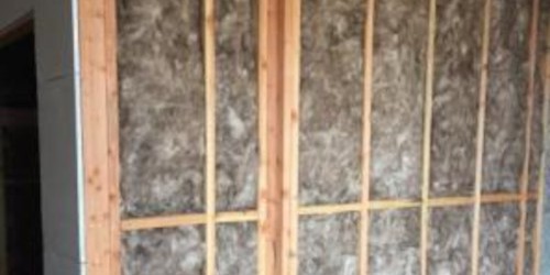 Exposed timber stud wall framing filled with insulation