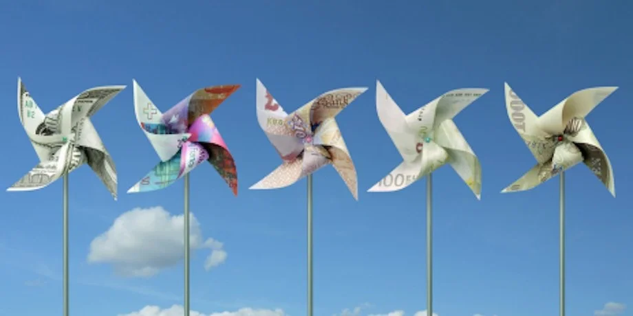 Row of colorful pinwheels or wind turbines against a blue sky