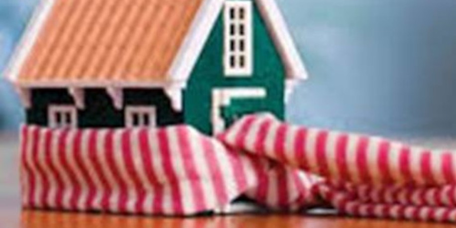 Toy house model resting on a soft striped cushion