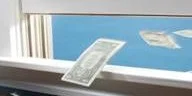 Banknotes flying out of an open window