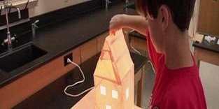 Child interacting with a small illuminated model house