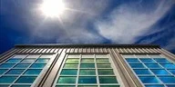 Low angle view of a modern building facade under a bright sun
