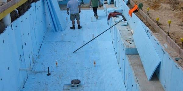 Outdoor swimming pool under construction with blue insulation/liner visible