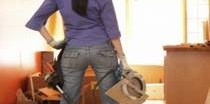 Person wearing a toolbelt standing in a room under renovation